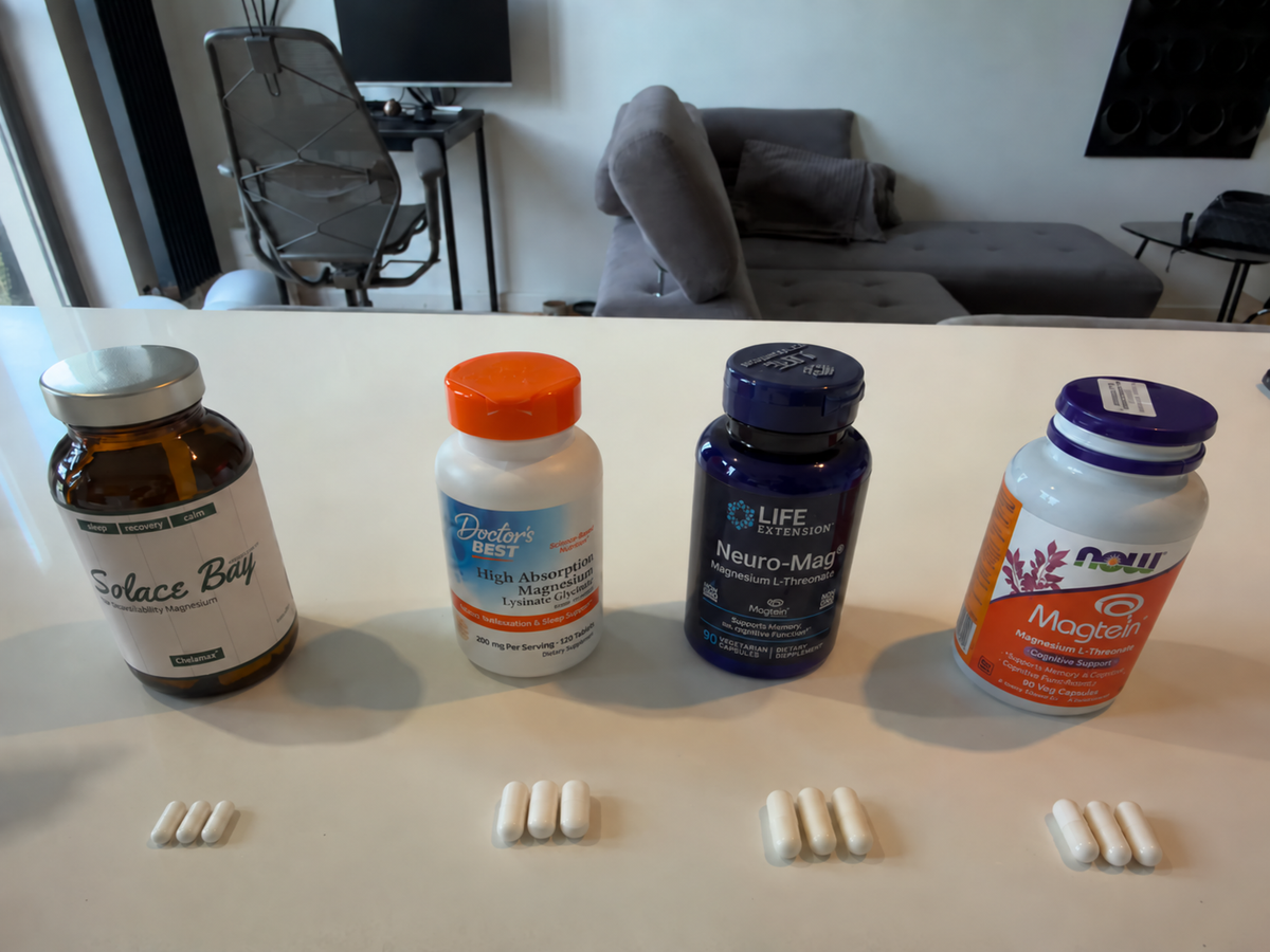 Four magnesium supplements lined up on a kitchen counter with handwritten labels